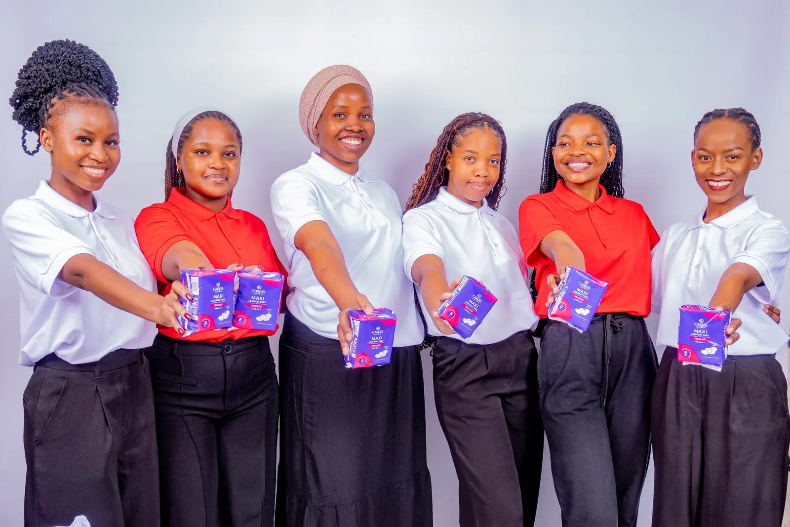 Her Essence volunteers holding sanitary towel packs