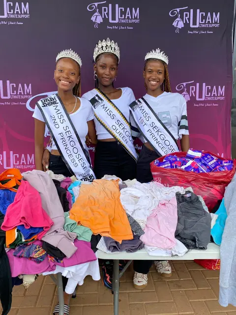 Miss Sekgosese queens behind a table of donated clothing